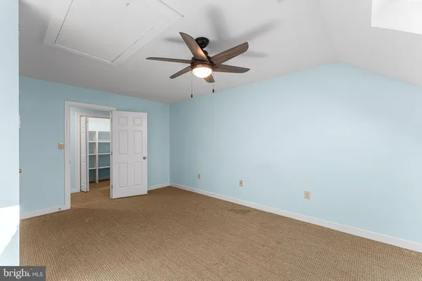 an empty room with closet and windows