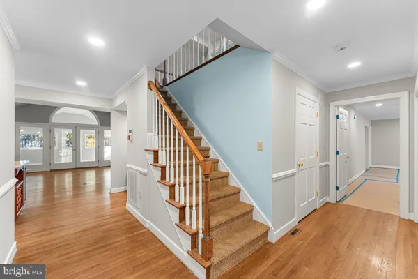 a view of a hallway with wooden floor and staircase