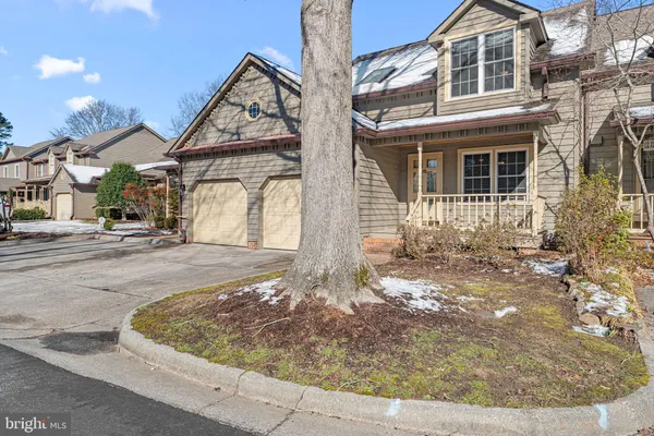 a view of a house with a small yard plants and large tree