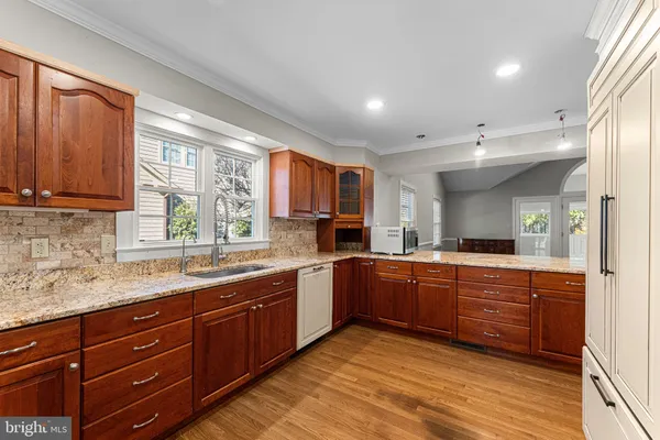 a kitchen with stainless steel appliances granite countertop wooden cabinets sink and window