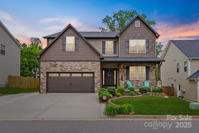a front view of a house with a garden and plants