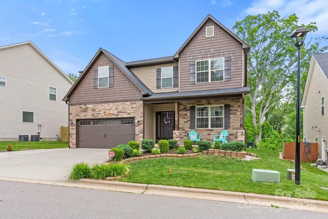 a front view of a house with a garden and plants