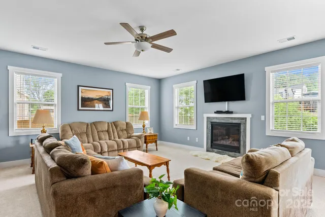 a living room with furniture ceiling fan and a fireplace