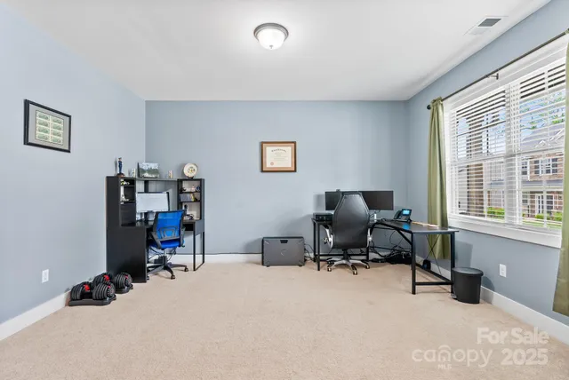 a view of a livingroom with workspace and a window