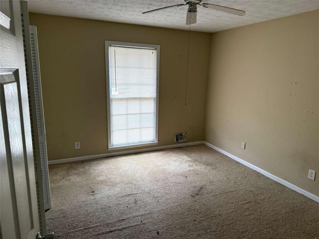 1960 Klondike Road Southwest Conyers, GA 30094 - Photo 4 of 15 an empty room with a window and a ceiling fan