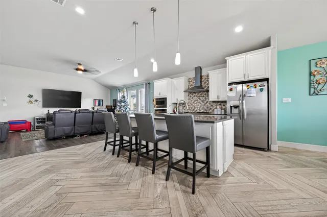 a large kitchen with a table chairs refrigerator and microwave