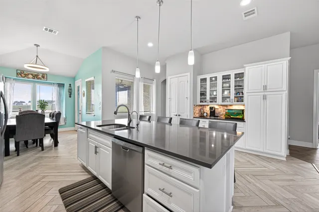 a kitchen with stainless steel appliances granite countertop a sink a stove and a wooden floors