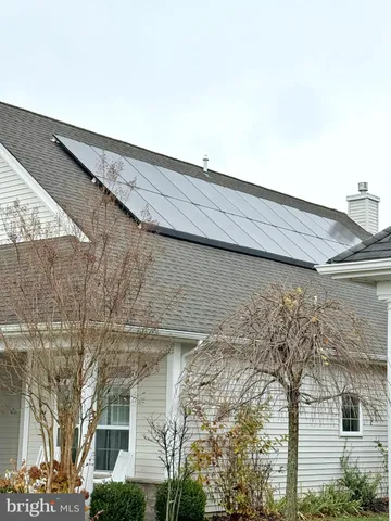 a balcony with table and chairs and potted plants