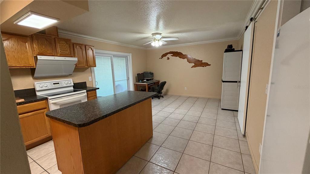 655 Murphy Road Winter Springs, FL 32708 - Photo 7 of 20 a kitchen with stainless steel appliances granite countertop a sink a stove a refrigerator a washer dryer and a dining table