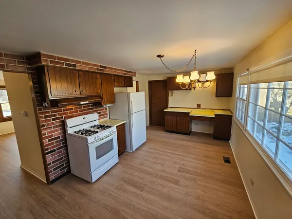 a kitchen with stainless steel appliances a stove cabinets and wooden floor