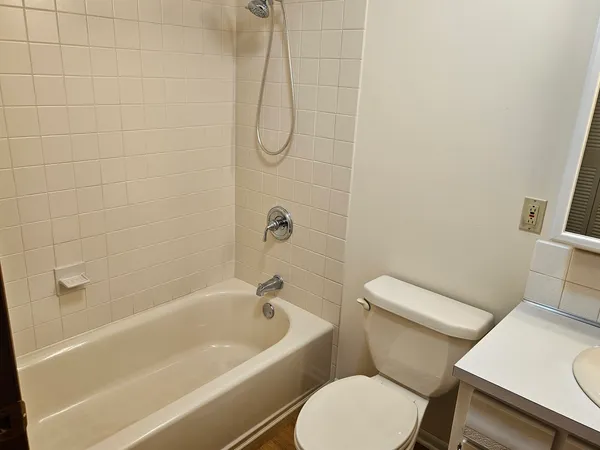 a white toilet sitting next to a bath tub and a shower
