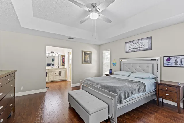 a bedroom with a large bed a chandelier and a window