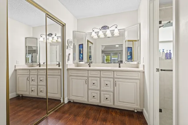 a spacious bathroom with double vanity a a fireplace and wooden floor