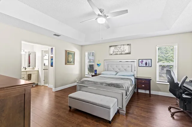 a spacious bedroom with a bed and a table in it with wooden floor