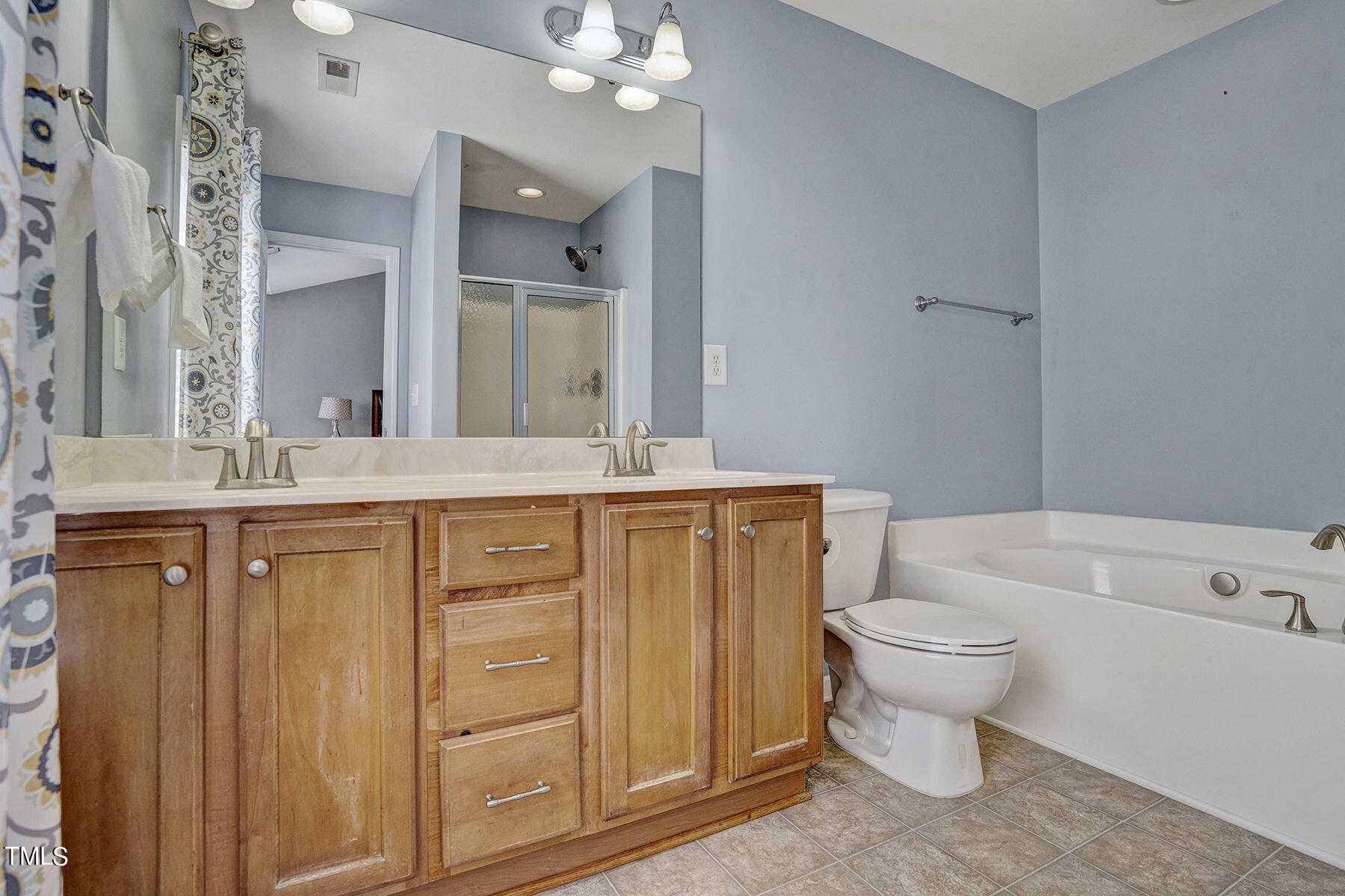 4630 Altha Street Raleigh, NC 27606 - Photo 24 of 31 a bathroom with a sink toilet a mirror a vanity and bathtub