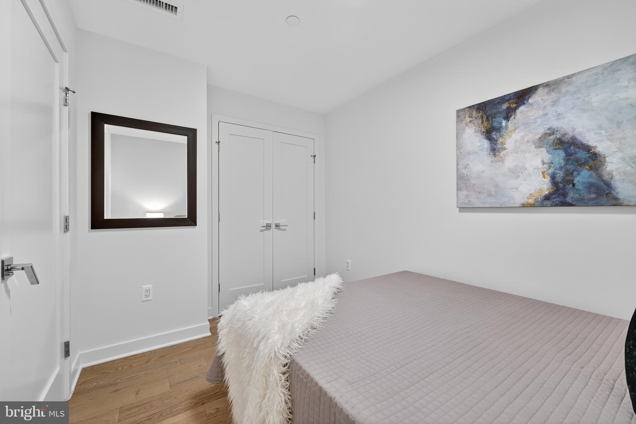 37 L Street Southeast, Unit A701 Washington, DC 20003 - Photo 12 of 45 a bedroom with a bed and a wall painting