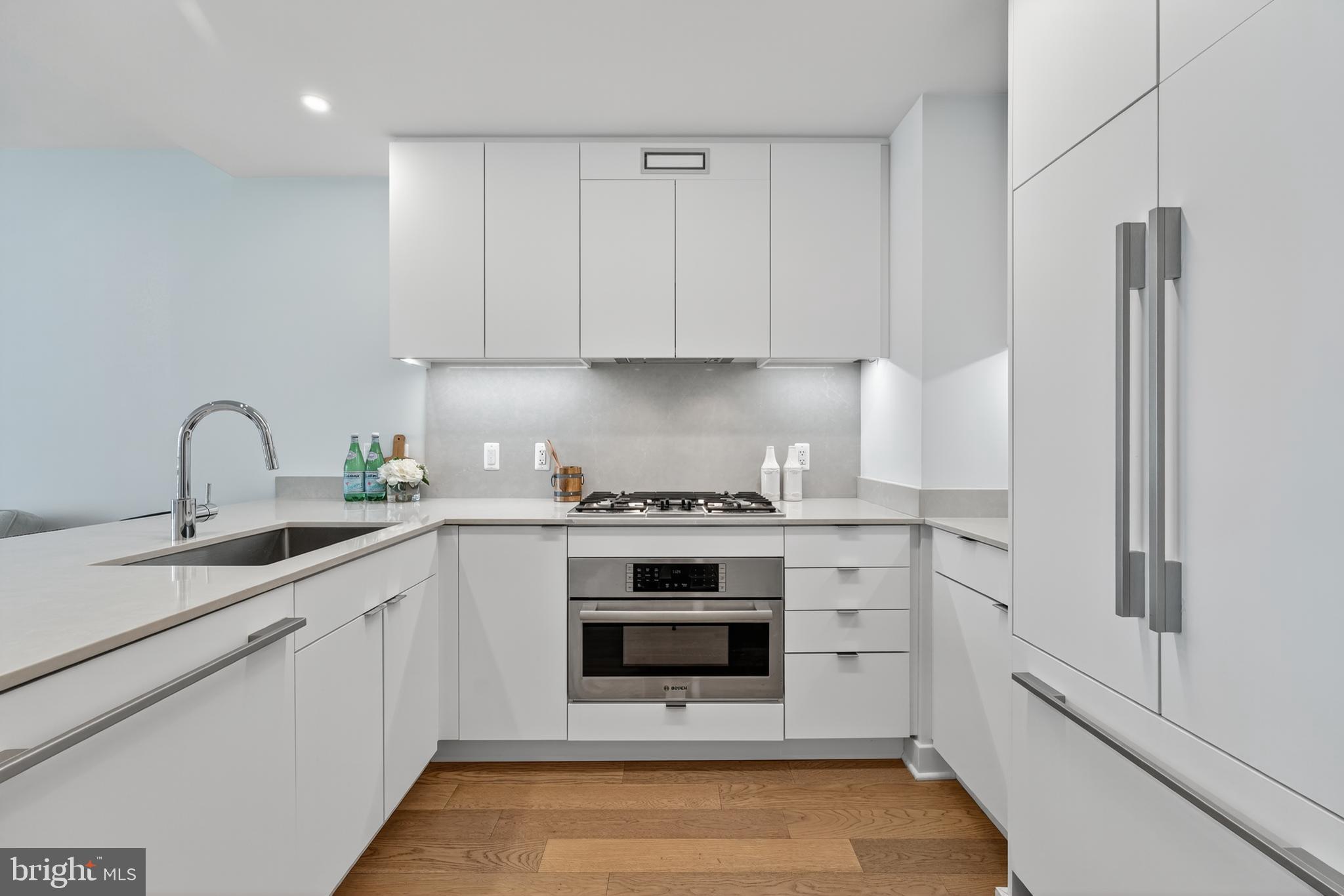 37 L Street Southeast, Unit A701 Washington, DC 20003 - Photo 6 of 45 a white kitchen with stainless steel appliances granite countertop a stove a sink and a refrigerator