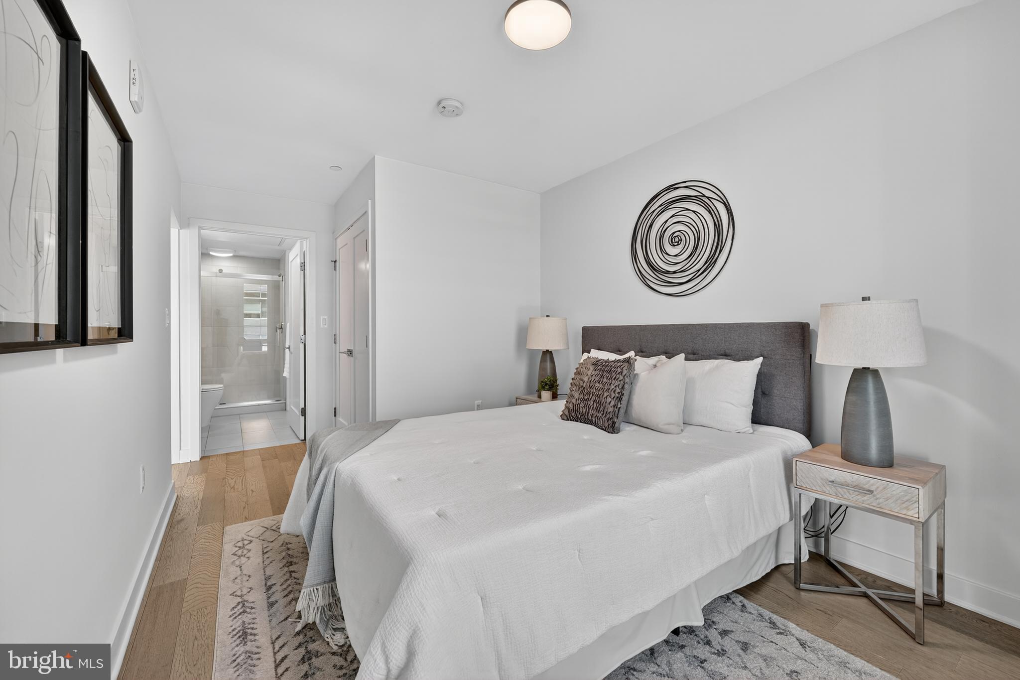 37 L Street Southeast, Unit A701 Washington, DC 20003 - Photo 8 of 45 a bedroom with a bed and a lamp on dresser