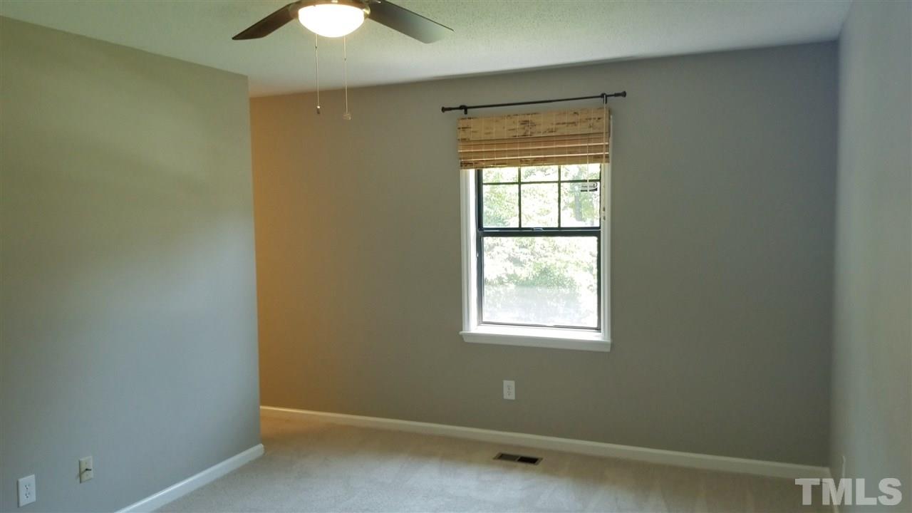 810 Wyldewood Road Durham, NC 27704 - Photo 12 of 23 an empty room with a window and a chandelier fan