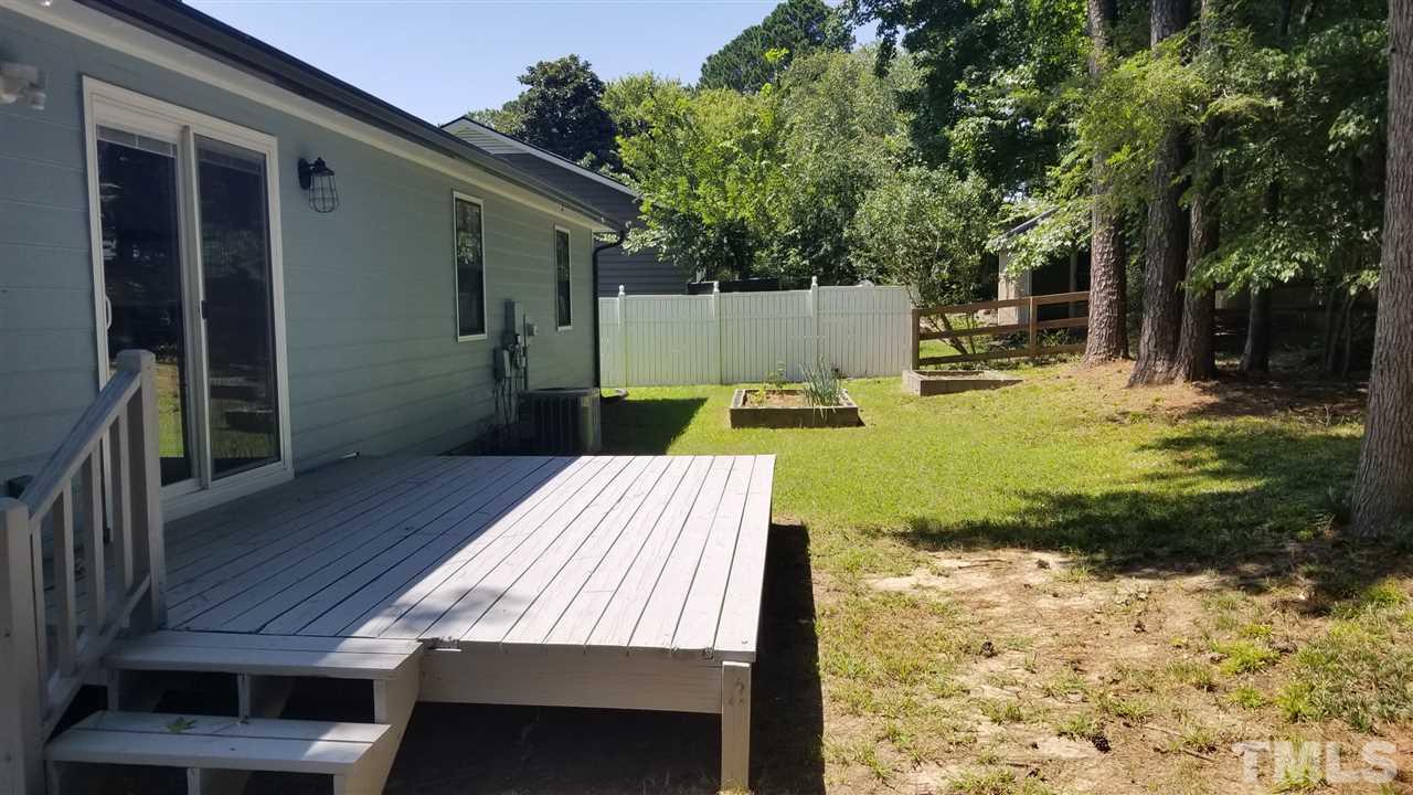 810 Wyldewood Road Durham, NC 27704 - Photo 19 of 23 a view of a backyard with table and chairs with wooden fence and plants