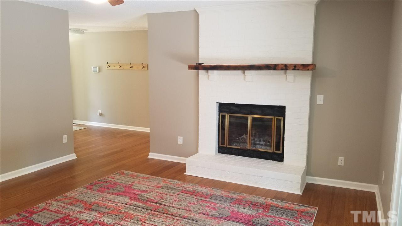 810 Wyldewood Road Durham, NC 27704 - Photo 3 of 23 a view of a livingroom with wooden floor and a fireplace
