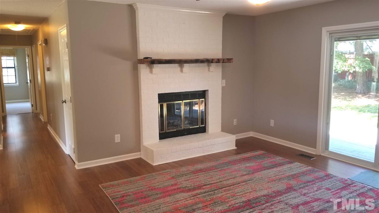 810 Wyldewood Road Durham, NC 27704 - Photo 4 of 23 a living room with wooden floor and a fireplace