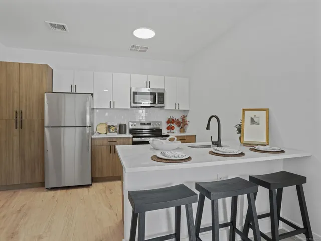 a kitchen with stainless steel appliances granite countertop a dining table and chairs