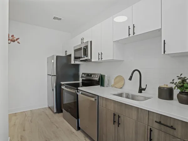 a kitchen with stainless steel appliances a sink cabinets and a refrigerator