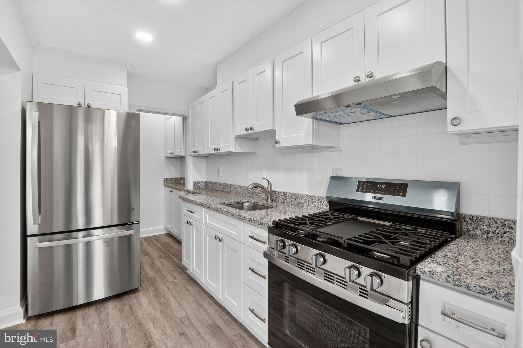 8258 Kavanagh Road Baltimore, MD 21222 - Photo 8 of 19 a kitchen with granite countertop a stove sink refrigerator and cabinets