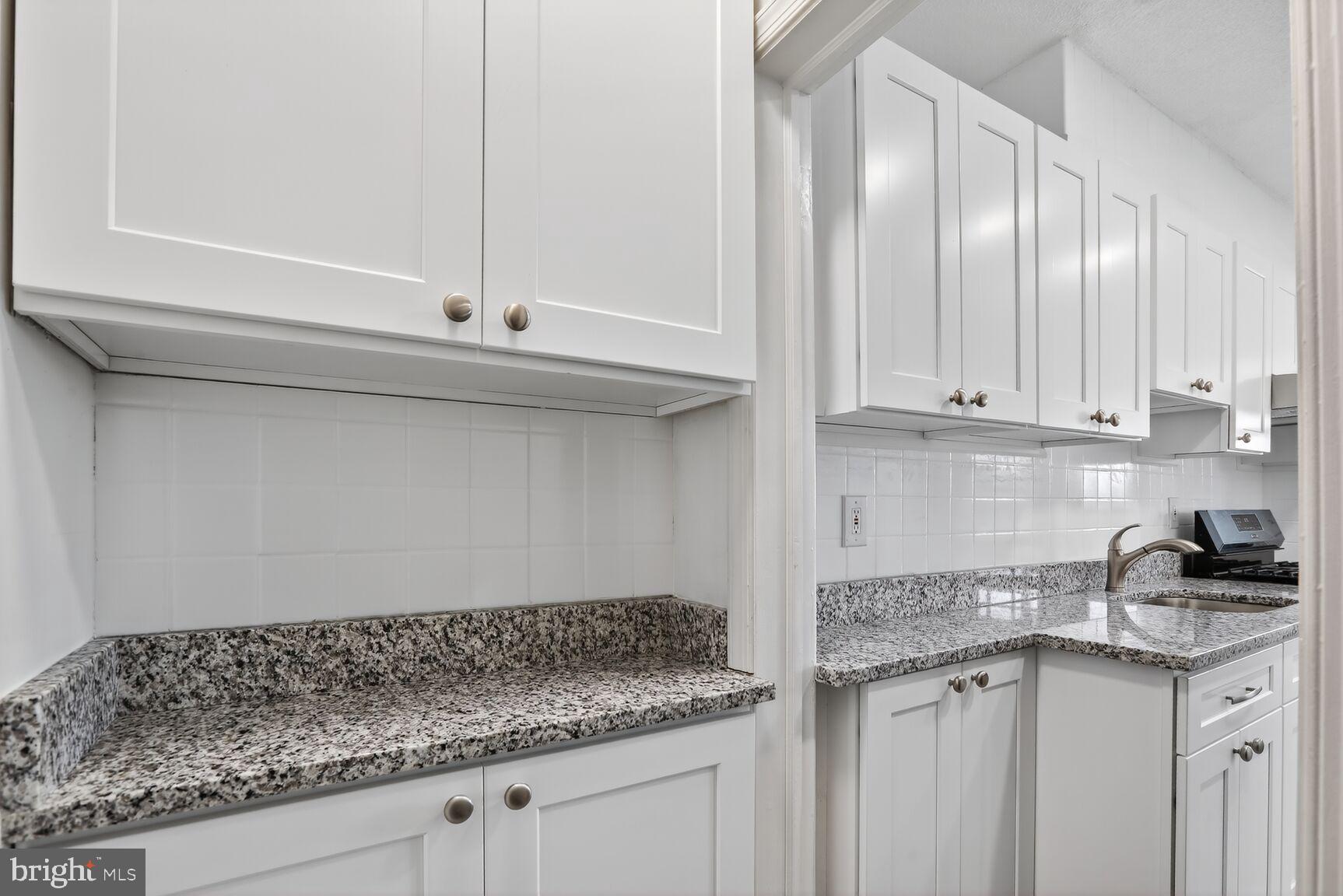 8258 Kavanagh Road Baltimore, MD 21222 - Photo 9 of 19 a kitchen with granite countertop white cabinets and a sink