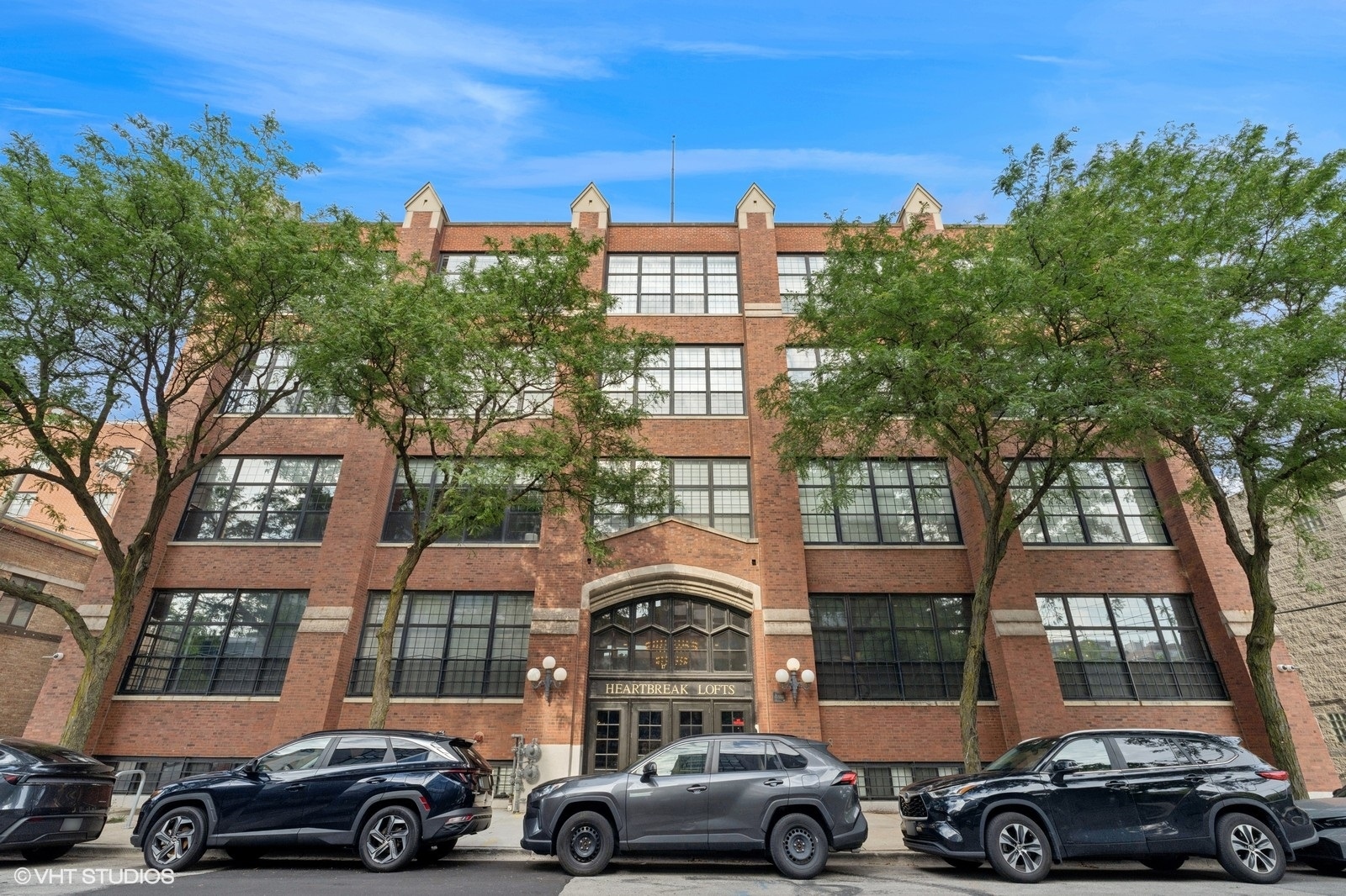 a front view of a residential apartment building with a yard