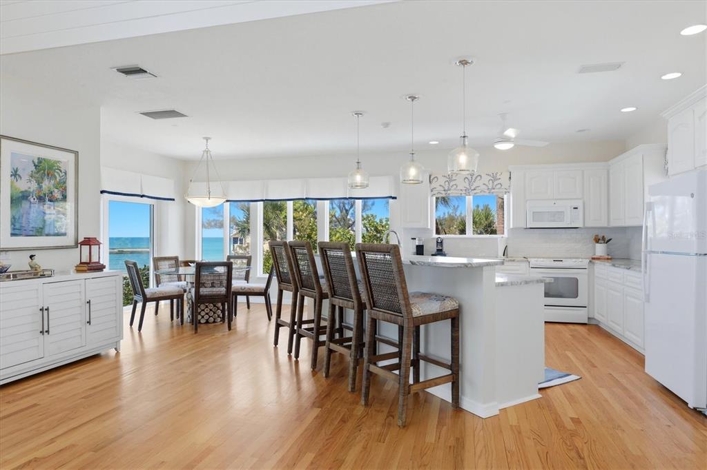 400 South Gulf Boulevard Boca Grande, FL 33921 - Photo 17 of 80 a kitchen with lots of white furniture appliances and wooden floor
