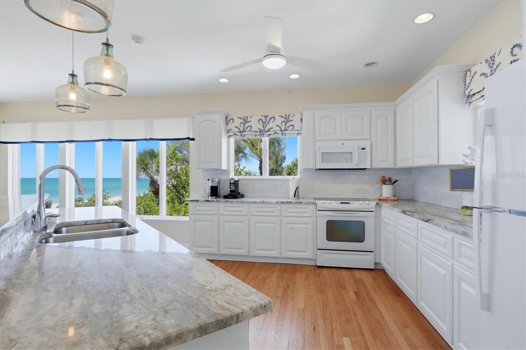400 South Gulf Boulevard Boca Grande, FL 33921 - Photo 18 of 80 a large kitchen with kitchen island a large counter top space a sink stainless steel appliances and cabinets