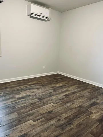 an empty room with wooden floor and entrance
