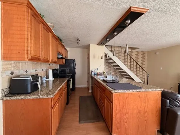 a kitchen with stainless steel appliances granite countertop a stove a sink and a refrigerator