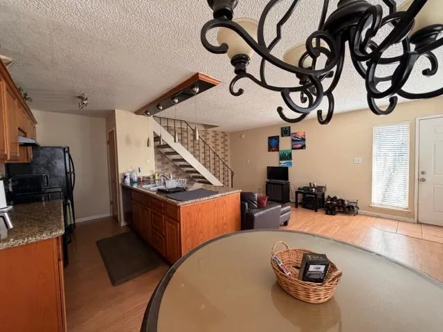 a kitchen with stainless steel appliances kitchen island granite countertop a stove and a wooden floors