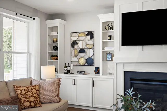 a living room with furniture a flat screen tv and a fireplace