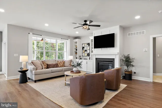 a living room with furniture a fireplace and a flat screen tv