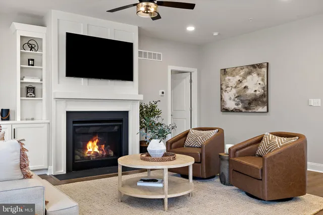 a living room with furniture a fireplace and a flat screen tv