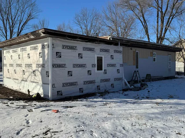 a view of a house with a wooden fence