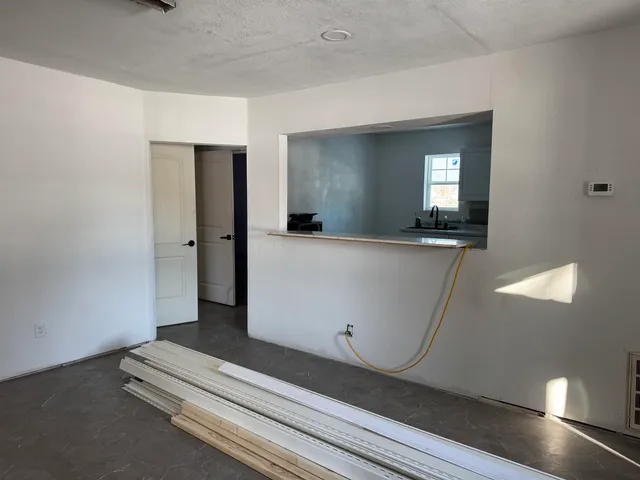 an empty room with wooden floor and mirror