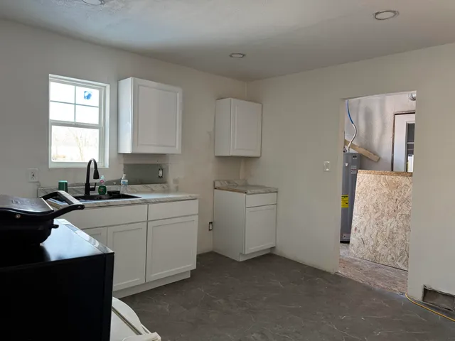 a kitchen with cabinets stainless steel appliances and a window