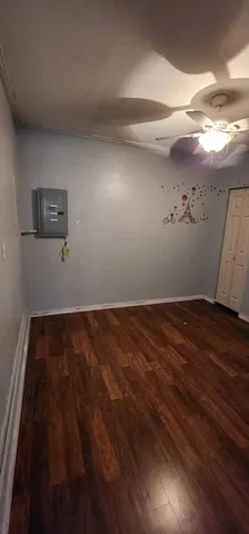 a view of a room with wooden floor and fan