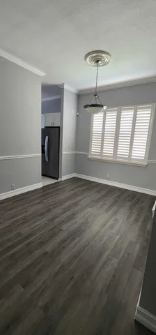 an empty room with wooden floor fireplace and windows