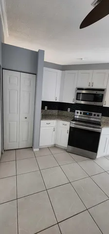 a kitchen with granite countertop a stove and a cabinets