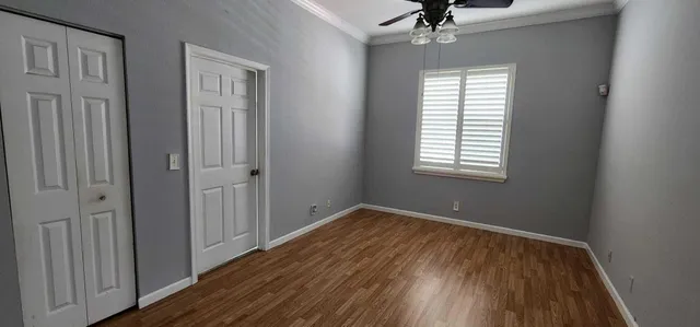 a view of an empty room with a window and wooden floor