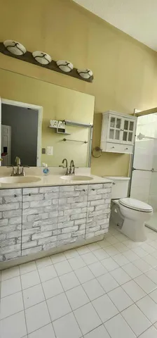 a bathroom with a sink a toilet and a mirror