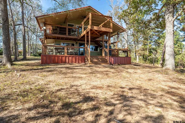 a view of a backyard with wooden fence and a large tree