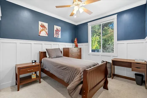 a bedroom with a bed table and window