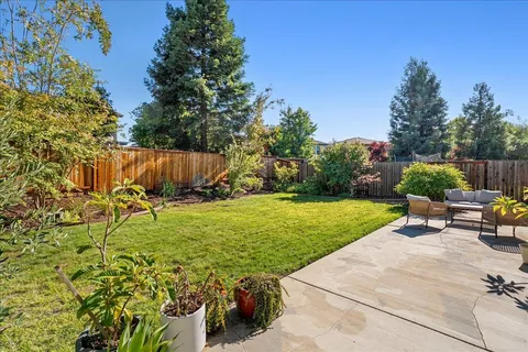 a view of backyard with seating area and green space